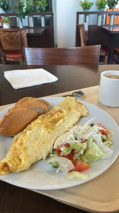 Frisch zubereitetes Omelett mit Brötchen, Salat und Kaffee im Imbiss am Fährterminal Rostock